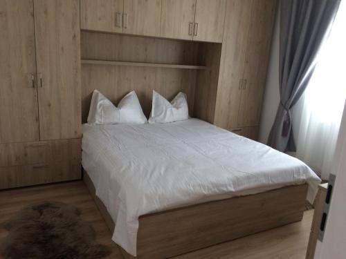 ブラショヴにあるApartament de inchiriat OLIMPIC REZIDENCEのベッドルーム1室(白いシーツと枕のベッド1台付)