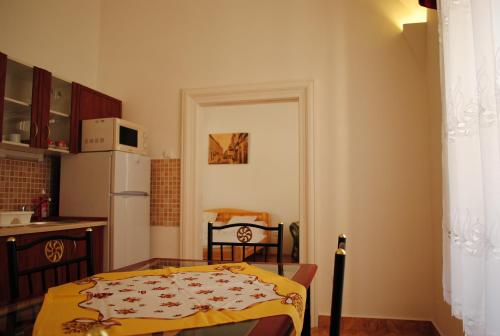 eine Küche mit einem Tisch und einer gelben Decke darauf in der Unterkunft Dobó Téri Apartman in Eger