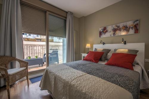 バレンシアにあるBeds & Breaks Nymanのベッドルーム1室(赤い枕のベッド1台、窓付)