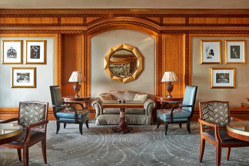 a living room with a couch and a table and chairs at Four Seasons Hotel Cairo at Nile Plaza in Cairo