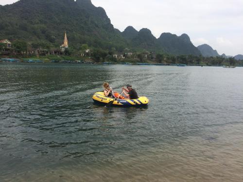 a man and a child on a raft in the water at Carambola Bungalow in Phong Nha