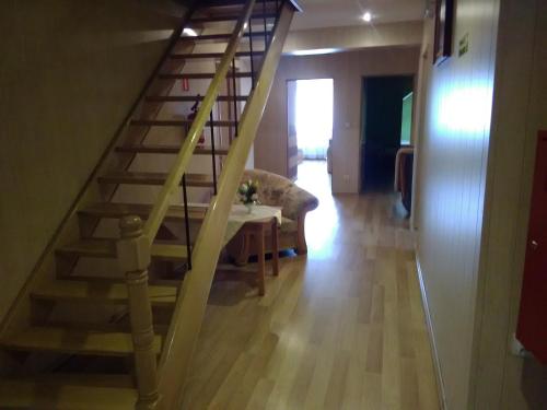 a wooden staircase in a living room with a table at Zajazd Zagłoba in Widoma