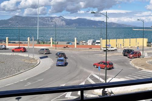 a parking lot with cars on a road near the water at Hotel Atlantis in Corfu Town