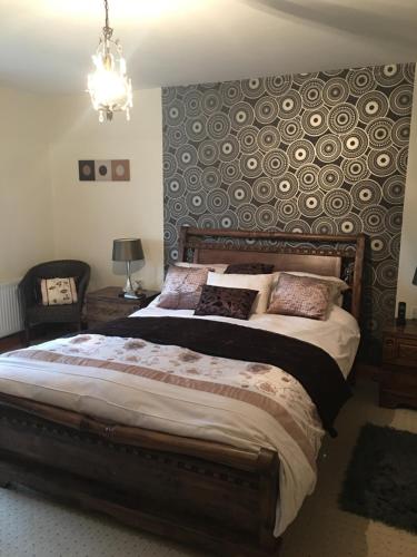 a bedroom with a large bed with a wall at Riverdale in Carlingford