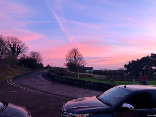 um carro estacionado na berma de uma estrada em Blue Bell Inn em Embleton