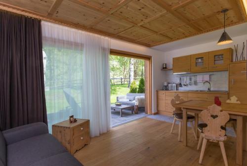 a kitchen and living room with a couch and a table at Appartement Pichler in Dobbiaco