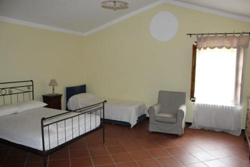 a bedroom with two beds and a chair and a window at Fontanacota in Imperia