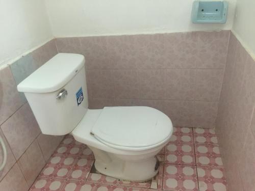 a bathroom with a white toilet in a room at Dalom Guesthouse in Don Det