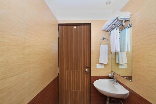 a bathroom with a sink and a mirror at La Sara Comforts in Bangalore