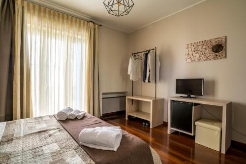 una camera da letto con un letto, una tv e una finestra di A casa di Alberto a Monopoli