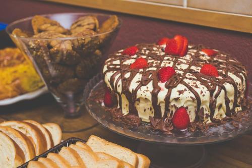 ein Kuchen mit Erdbeeren und Schokolade auf einem Tisch mit Brot in der Unterkunft Comfort Hotel Araraquara in Araraquara