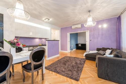 ワルシャワにあるP&O Apartments Metro Nowy Swiatの紫の壁のリビングルーム(ソファ付)