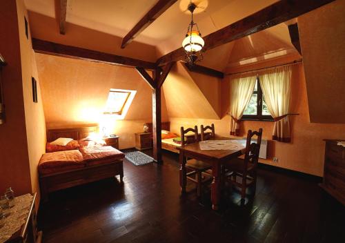 a room with a bed and a table and a bed and a bedroom at Stylowy Zajazd Pod Czarnym Kogutem in Czarna