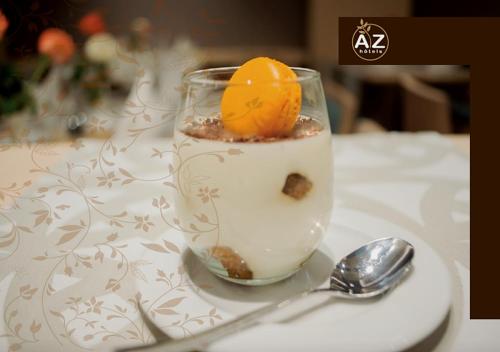 a glass of milk with an orange on a table at AZ Hôtels Vieux Kouba in Alger