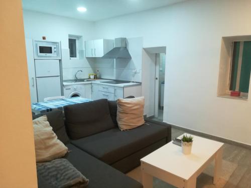 a living room with a couch and a kitchen at La Casa de Yiyi in San José