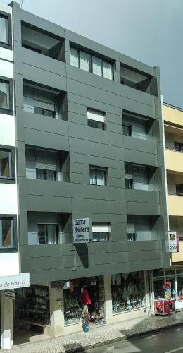 a gray building with a sign that reads quiet supermarket at Santa Barbara by Umbral in Fátima