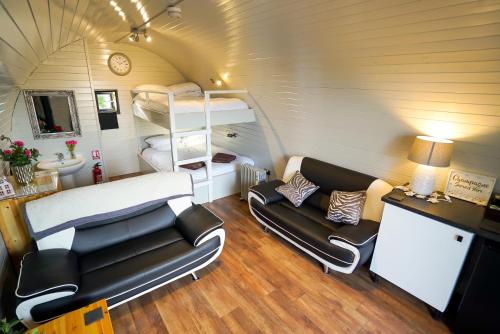 a small room with a couch and a bunk bed at Deluxe Glamping Pod with Hot Tub in Frodsham