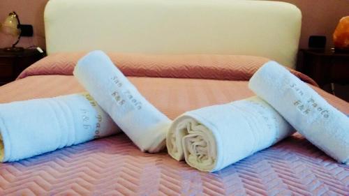 a bed with two rolled up towels on it at B&B San Paolo in Campagna