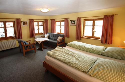 1 dormitorio con 2 camas y sala de estar en Haus & Heim Ferienwohnung, en Oberstdorf