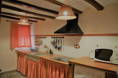 cocina con 2 luces colgantes y microondas en Casa Tolosa, en Las Cuerlas