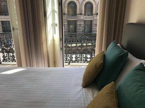 a bedroom with a bed with a view of a balcony at Apartamento Cardosas, São Bento in Porto