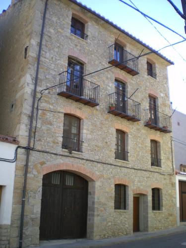 a large stone building with two entrances and two balconies at La Posada in Cantavieja