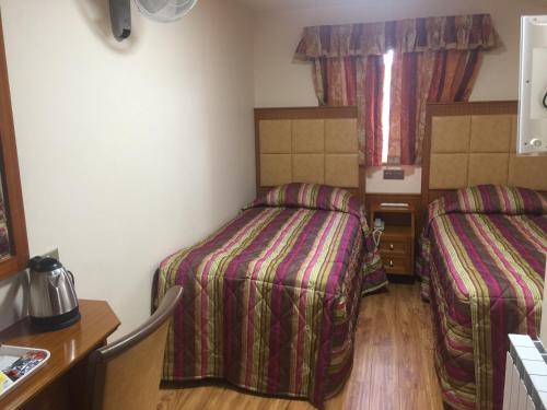a hotel room with two beds and a window at White House Hotel in London