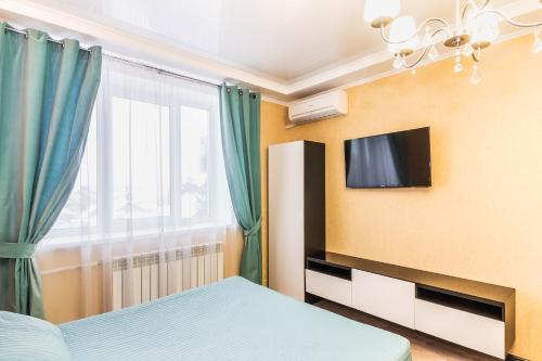 ブズルクにあるМосковская 79のベッドルーム1室(ベッド1台、壁掛けテレビ付)