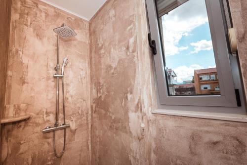 a shower in a bathroom with a window at Boutique Hostel Livia in Metković