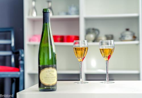 uma garrafa de vinho e dois copos numa mesa em Appartement Place Kléber em Estrasburgo