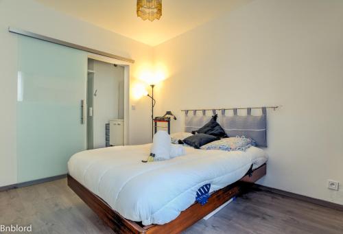 um quarto com uma cama grande e lençóis brancos em Appartement Place Kléber em Estrasburgo