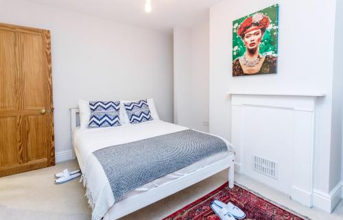 1 dormitorio con 1 cama y una pintura en la pared en The Modern Classic - Contemporary & Elegant 3BDR Home en Cambridge