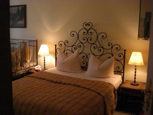 a bedroom with a bed with pillows and two lamps at Hotel Mariahilf München in Munich