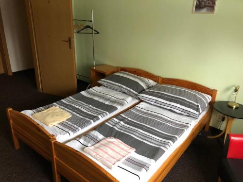 a bed with gray and white blankets and pillows at Penzion Tetřívek in Nové Hutě