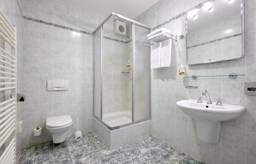 a bathroom with a toilet and a sink and a shower at Apartments Central Park Marienbad in Mariánské Lázně