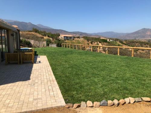 a backyard with a lawn and a wooden fence at Villas Toscanas in Limache