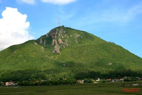 a green hill with a cross on top of it at Tic Guest House in Liên Trì (3)