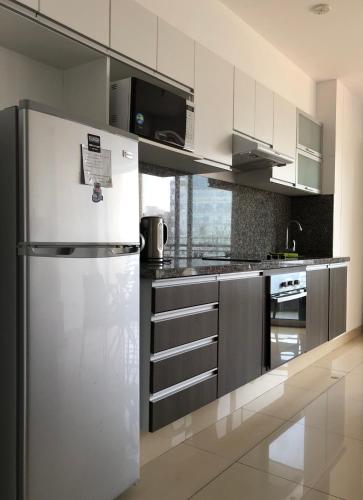 a white kitchen with a refrigerator and a stove at Terrazas Apartments Miraflores in Lima
