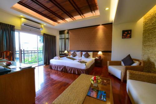 a hotel room with two beds and a couch at Rapeepan Ville Hotel in Ubon Ratchathani