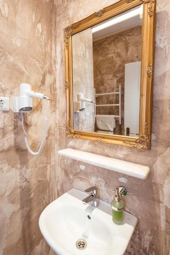 a bathroom with a sink and a mirror at Boutique Hostel Livia in Metković