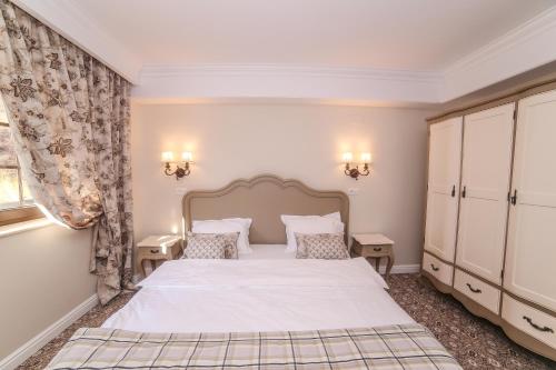 a bedroom with a large bed and two night stands at PENSIUNEA DIMITRIOS Relaxare cu jacuzzi pe Valea Cernei in Băile Herculane