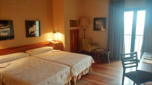 a hotel room with a large bed and a desk at Parador de Vielha in Vielha