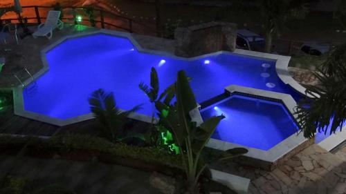 an overhead view of a blue swimming pool at night at Solar do Forte Flats in Ubatuba