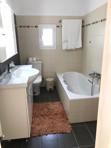 a bathroom with a tub and a sink and a toilet at Villa Korais Luxury 3br apt with sea view in Thessaloniki