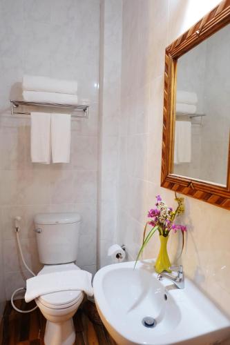 a bathroom with a toilet and a sink and a mirror at Aphilapa Residence in Chiang Mai