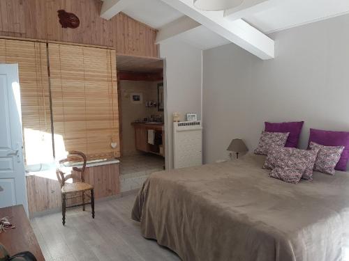 ランブクにあるDétente champêtreのベッドルーム1室(大型ベッド1台、紫色の枕付)