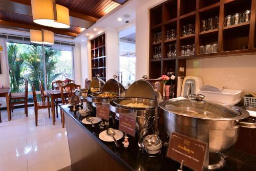 een buffet in een restaurant met twee grote potten eten bij Rapeepan Ville Hotel in Ubon Ratchathani