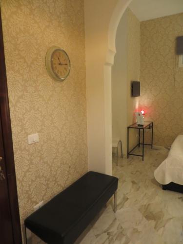 a room with a clock on the wall and a bench at B&B Mini Hotel Incity-close train station and port- in Salerno