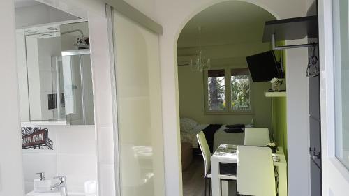 uma cozinha com um lavatório e uma mesa num quarto em Apartment Zara em Crikvenica