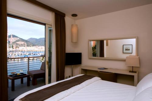 a hotel room with a bed and a large window at Marina Place Resort in Genova